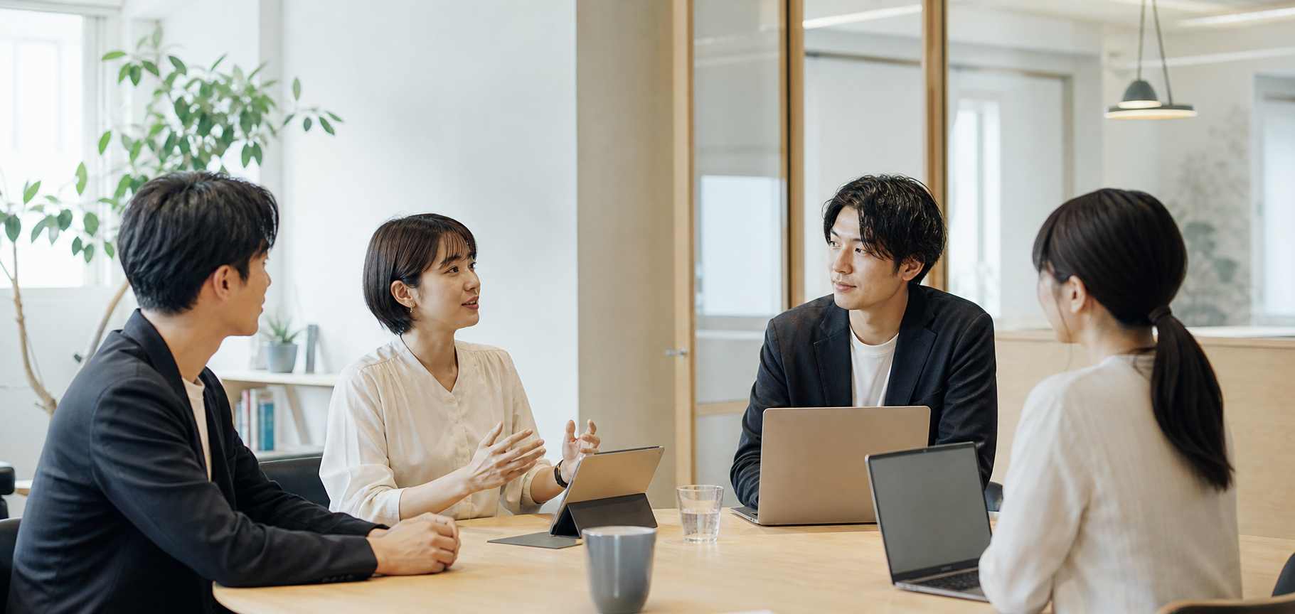 明るいオフィスで対話する人々のイメージ